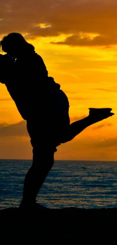 Silhouette of a couple embracing against a golden beach sunset.