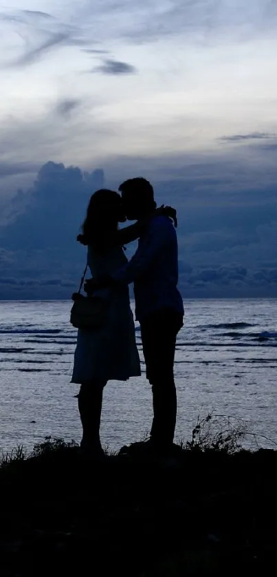 Silhouette of a couple at blue twilight on the beach.