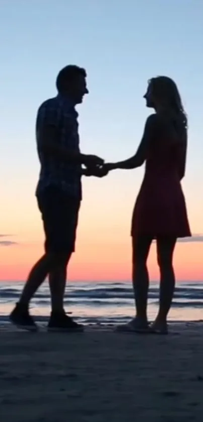 Silhouette of a couple holding hands at beach during sunset.