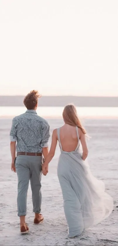 Couple walking on serene beach at sunset, holding hands romantically.