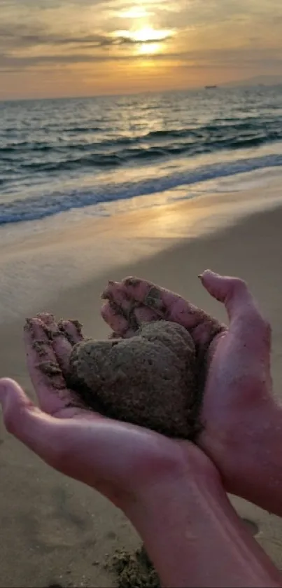 Hands holding heart-shaped sand at sunset on the beach.