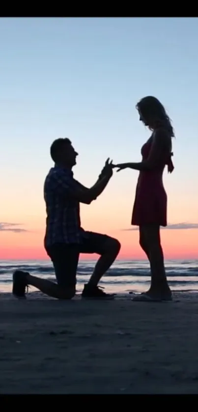 Silhouetted couple proposal during sunset on a beach.