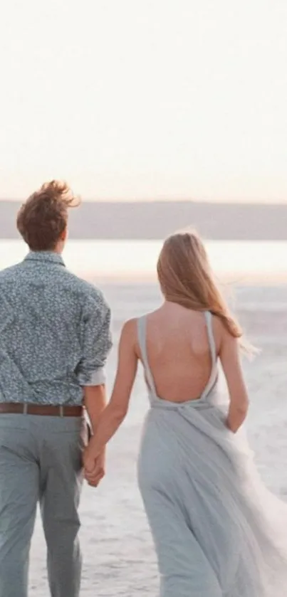 Couple walking hand-in-hand on a serene beach at sunset, perfect wallpaper.