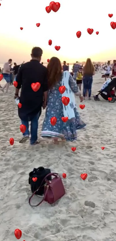 Couple walking on sandy beach with red hearts.