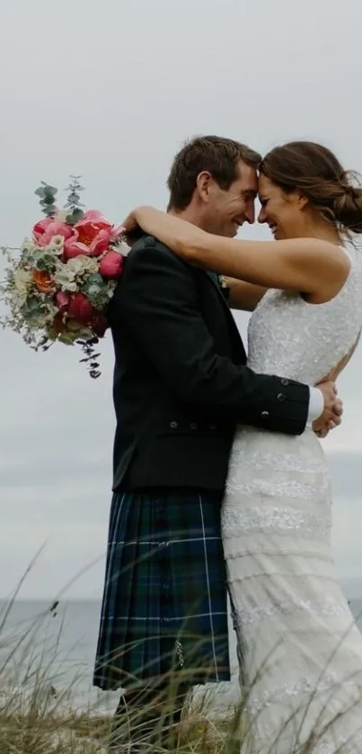 Couple embracing at beach wedding with floral bouquet