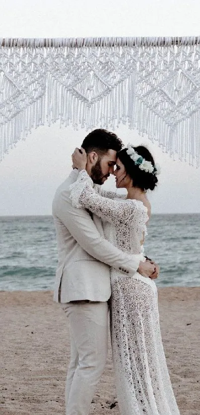 Romantic couple embracing at beach wedding under elegant arch.