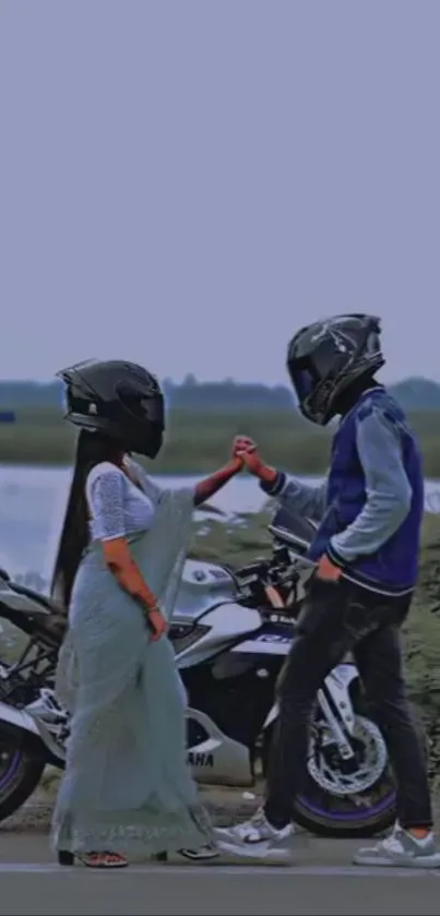 Romantic bikers holding hands with helmets and motorcycle.