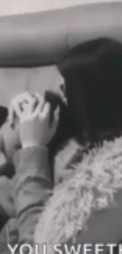 Black and white couple in tender embrace on couch.