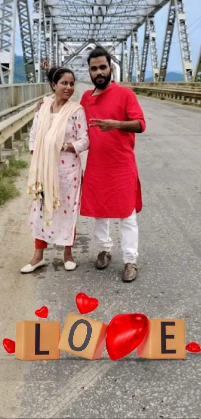 Couple on a bridge with LOVE sign and red hearts.