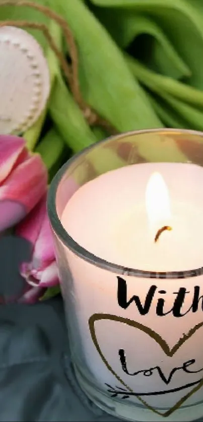 Candle with "With Love" text beside pink tulips.