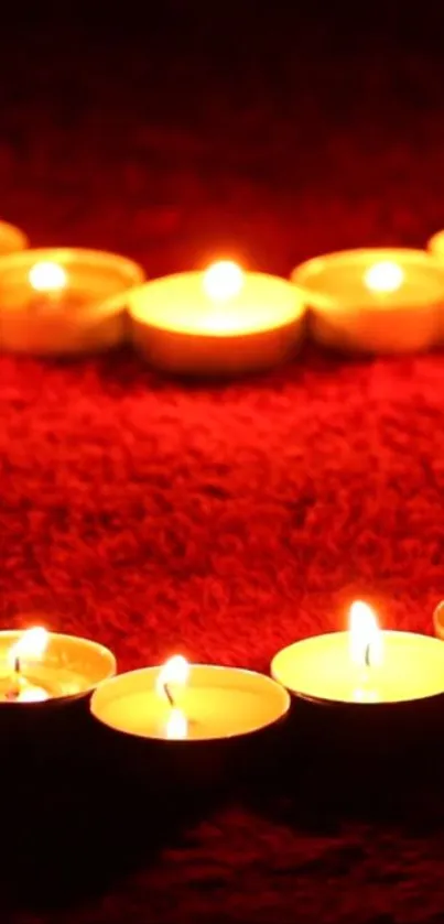 Heart-shaped candle arrangement on red background.