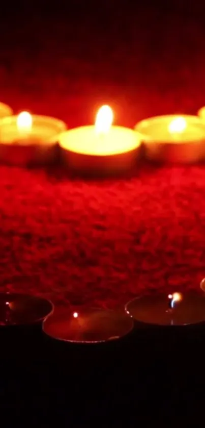 Romantic candlelit wallpaper with glowing candles on a red background.