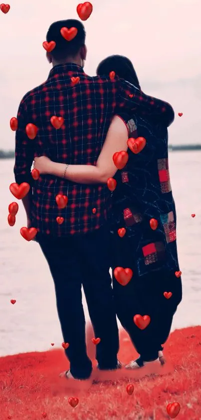 Romantic couple embraces by lake with floating red hearts.