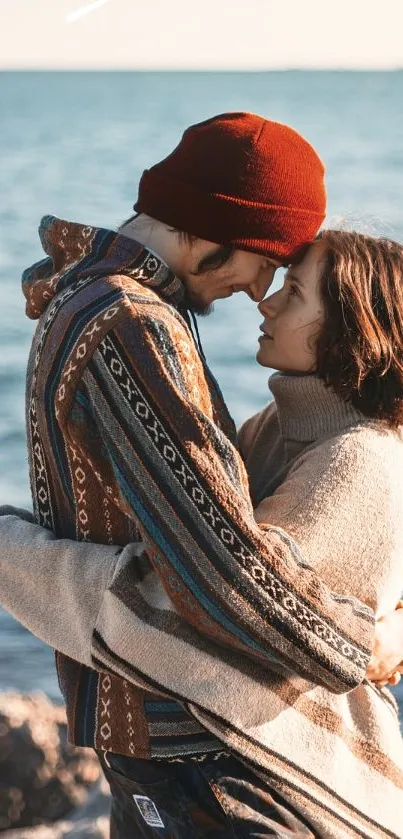 Couple embracing by the sea with rocky shore.