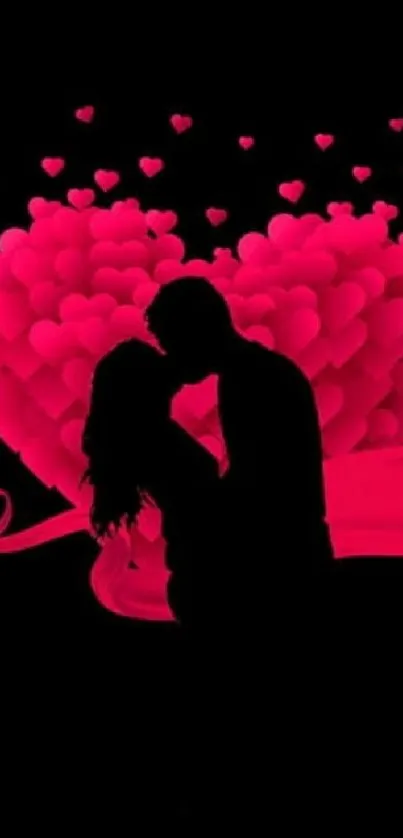 Silhouette of a couple embracing with a pink heart backdrop.