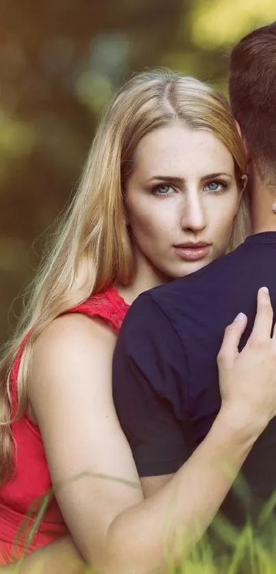 Romantic couple embracing in a green meadow with sunlight.