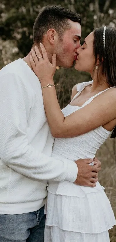 A couple sharing a romantic kiss in a natural outdoor setting.