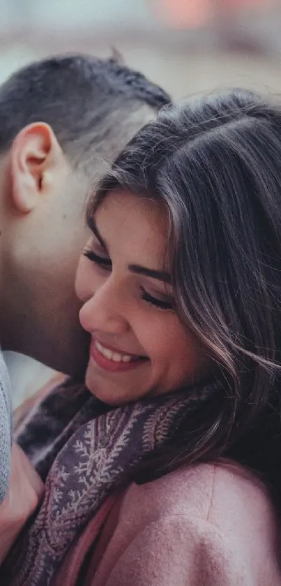 Couple sharing a warm embrace with festive lights in the background.