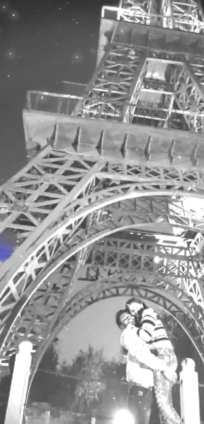 Couple under the Eiffel Tower at night with a starry sky.