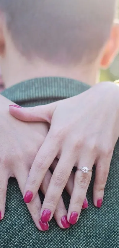 Romantic embrace showing woman's hands with an engagement ring