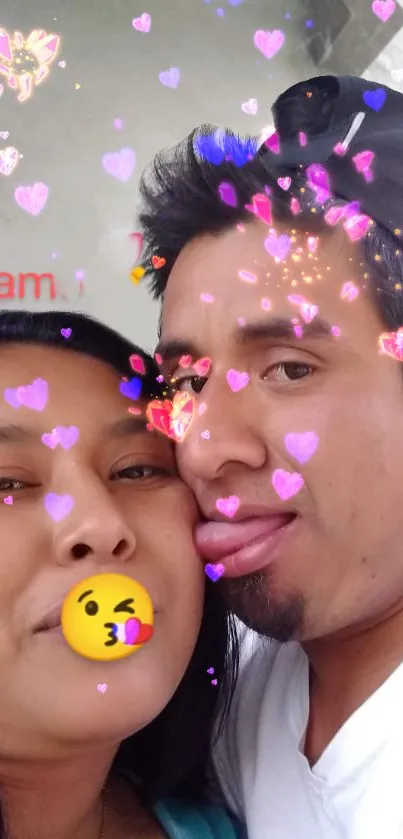 Romantic couple with heart emoji filter on wallpaper.