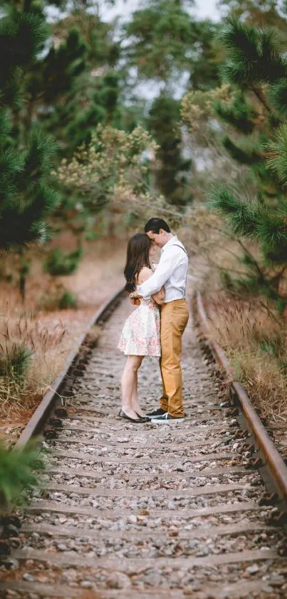 Romantic couple standing on forest railroad amidst greenery.