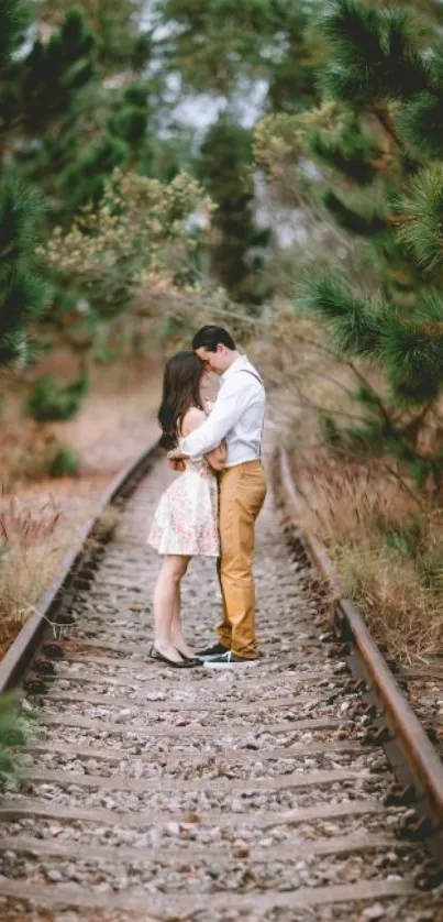 Couple embraces on forest railway track.