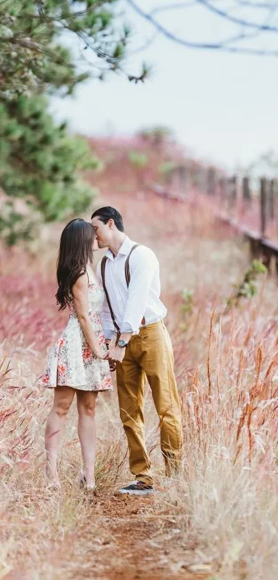 Couple walking through an autumn forest path with pinkish-brown foliage.