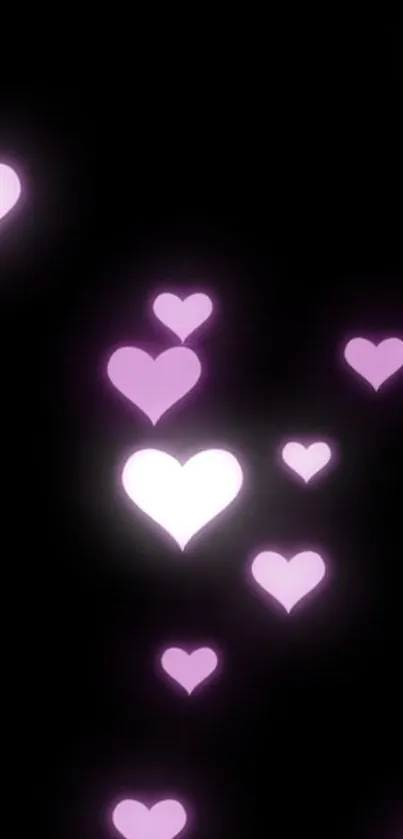 Wallpaper with glowing pink hearts on a black background.