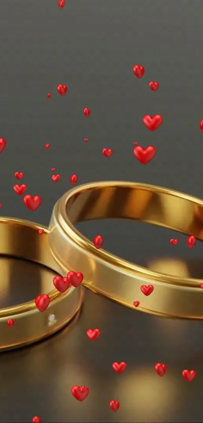 Gold rings with red hearts on dark background.