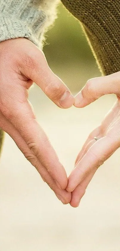 Hands forming a heart symbol on beige background.