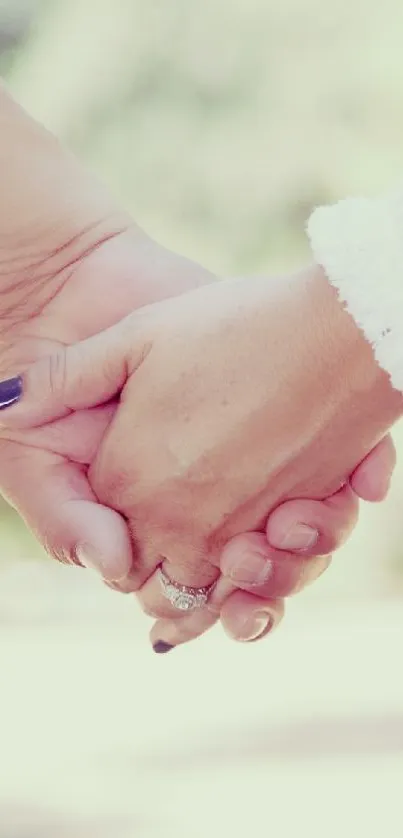 Two hands gently holding each other, set against a soft pastel background.