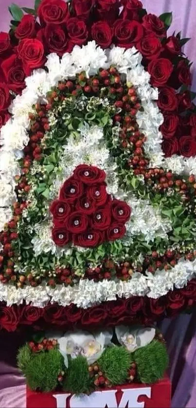 Heart-shaped floral arrangement with red roses and white blooms.