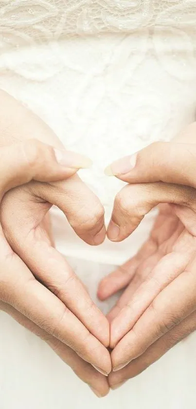 Romantic hands forming a heart shape on a soft cream background.