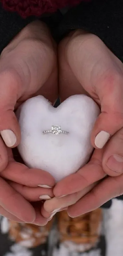 Hands hold a snow heart with a ring, capturing romance and winter charm.