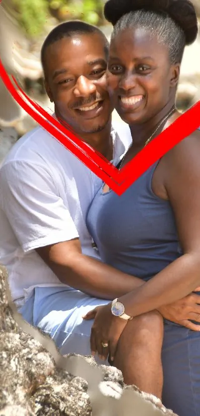 Couple embracing near tree with red heart.