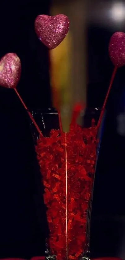 Vase with glittering red hearts in low light setting.