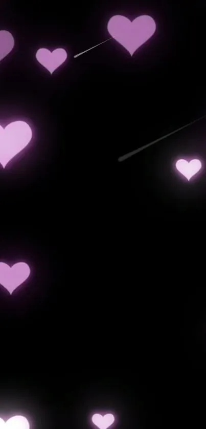 Glowing pink hearts on black wallpaper.