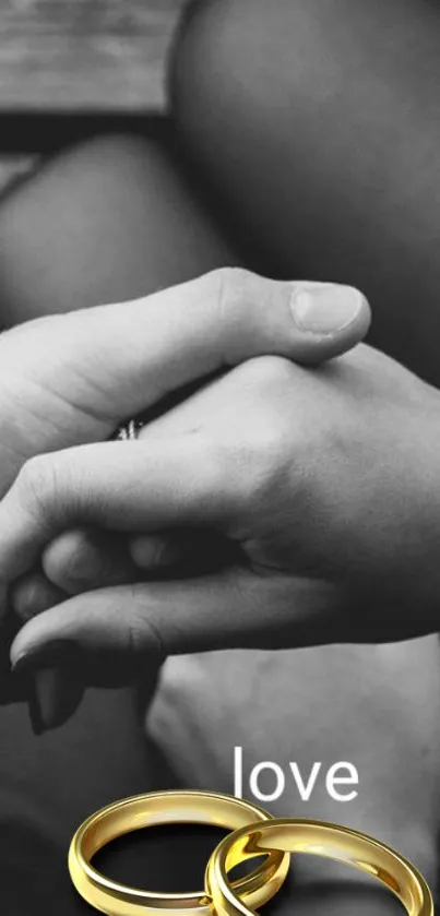 Couple holding hands with love text and golden rings.