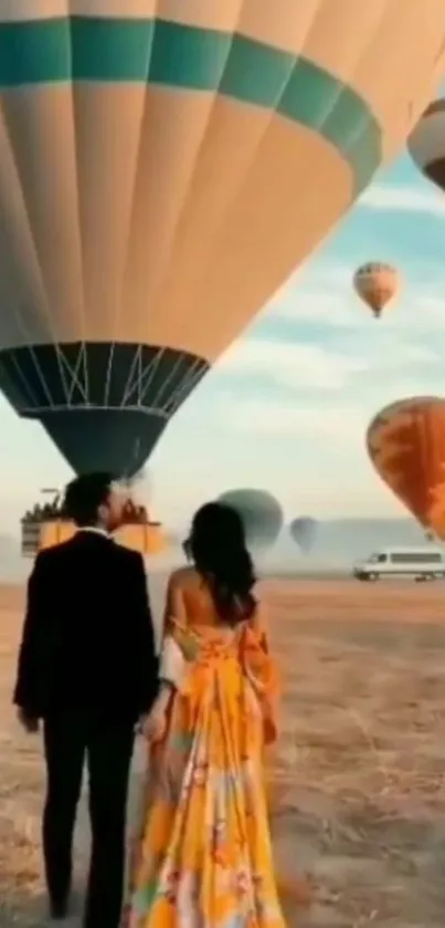 Couple under sky filled with hot air balloons enjoying a scenic view.