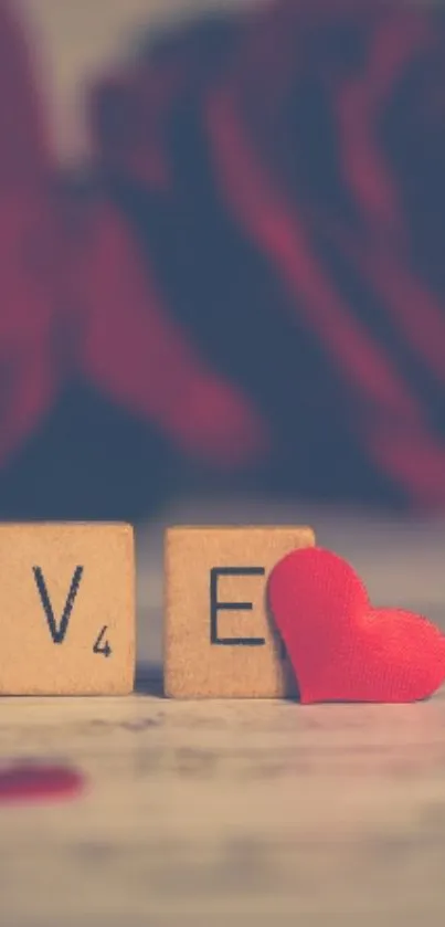 Love spelled with blocks and a red heart on a rose background.