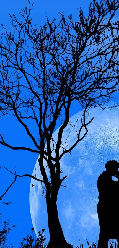 Silhouette of embracing couple under a tree with blue moonlit sky.