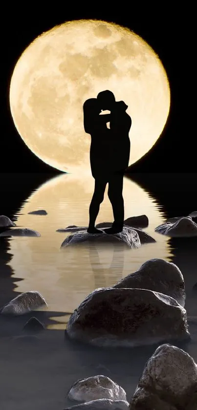 Silhouetted couple embracing by the moonlit water on rocks with a full moon.