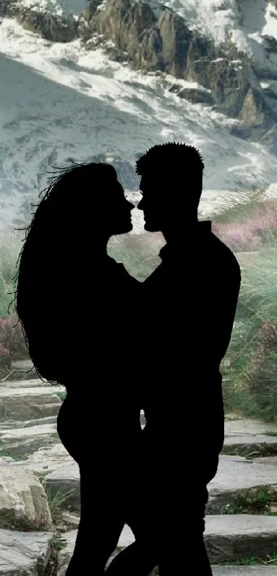 Silhouette of a romantic couple against a scenic mountain background.