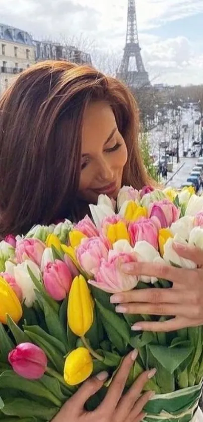 Woman holding colorful tulips with Eiffel Tower background.