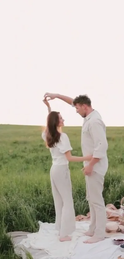 Romantic couple dancing in a meadow during a picnic at sunset.