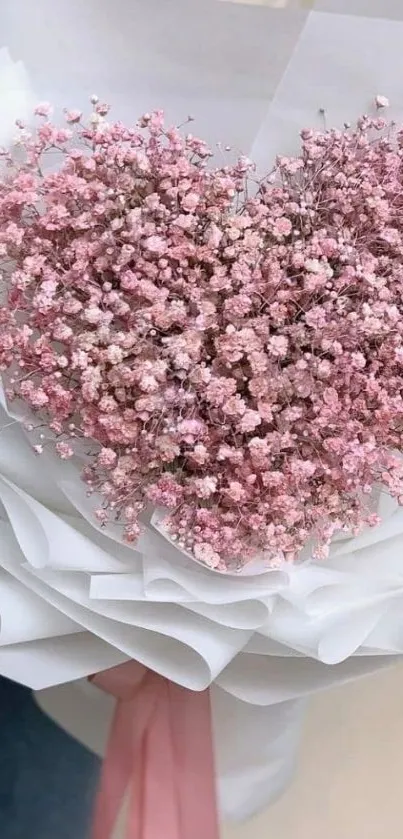 Heart-shaped pink flower bouquet on white wrapping paper.