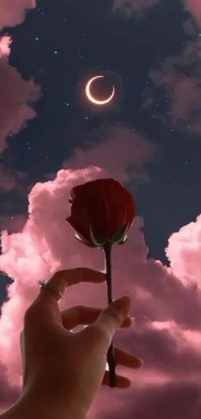 Hand holding rose under pink clouds and crescent moon.