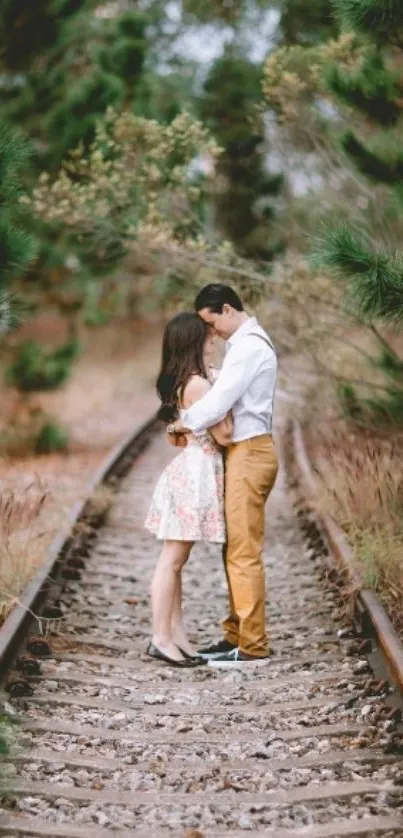 Couple embracing on a lush railway track amidst nature's serene setting.