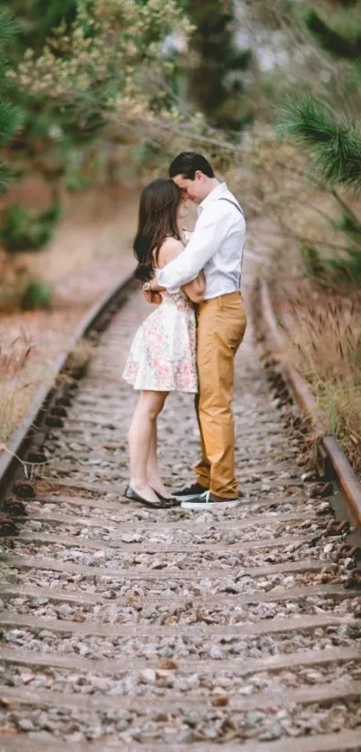 Couple embracing on scenic railroad track.